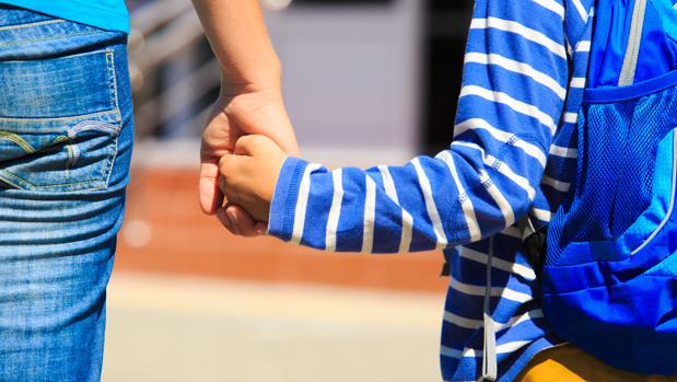 Una madre acompañando a su hijo al colegio