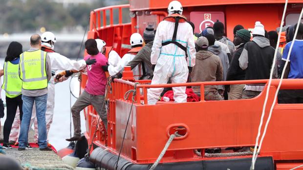 Autoridades y voluntarios de Cruz Roja ayudan a desembarcar en el puerto de ArguineguÍn, en Gran Canaria, a 152 personas que viajaban a bordo de un cayuco