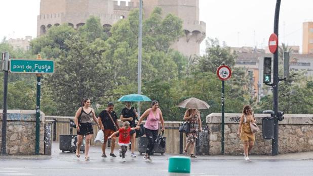 Transeúntes se protegen de la lluvia este lunes en Valencia