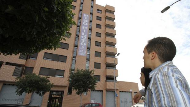 Una pareja observa pisos en venta en Alicante