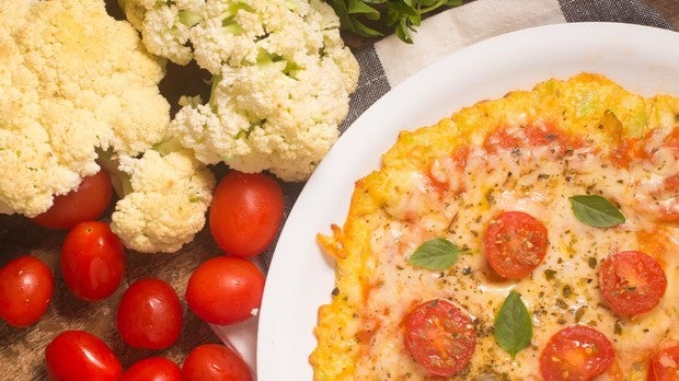 Pizza con base de coliflor y con tomates cherry.