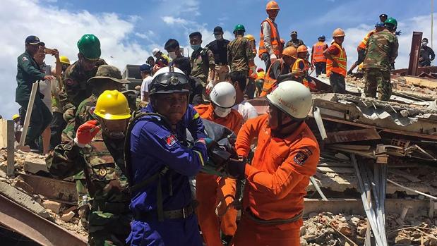 Los equipos de rescate sacan a una de las víctimas de entre los restos del edificio