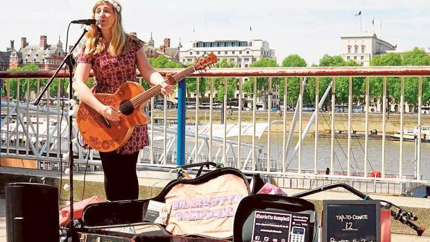 Una chica realiza una actuación musical callejera